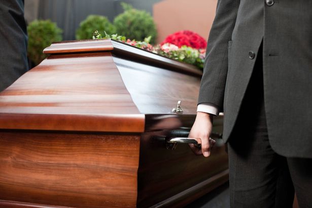 A funeral director preparing a respectful ceremony in a warmly lit chapel