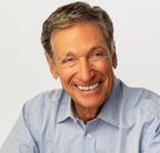 Maury Povich speaking on stage at a media event