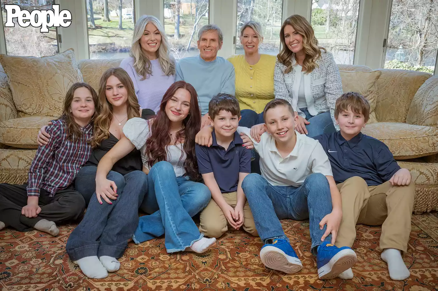 Michael Bolton smiling at home, surrounded by family, after brain tumor diagnosis and surgery.