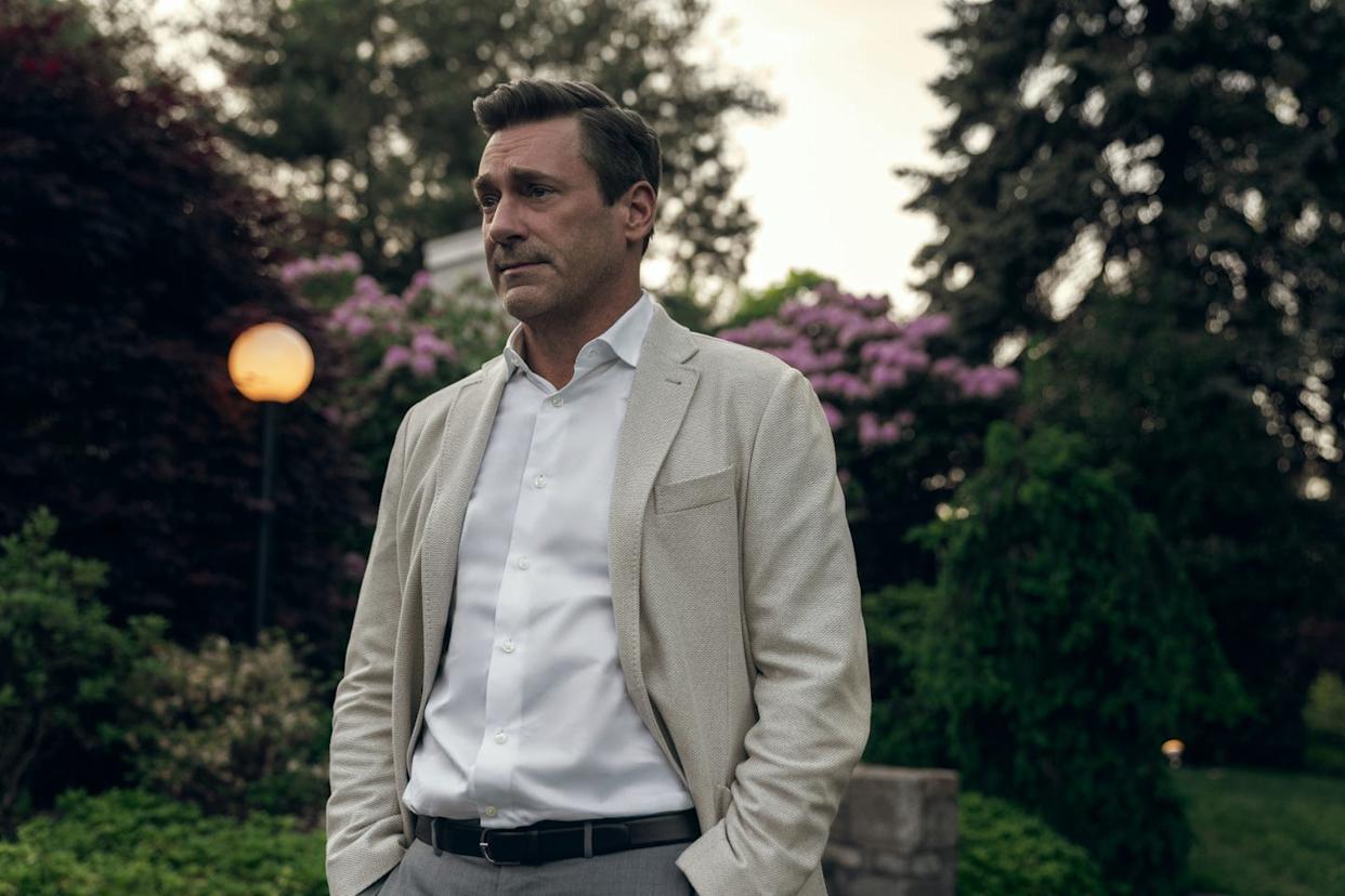 John Hamm smiling at a red carpet event, exuding confidence and charm