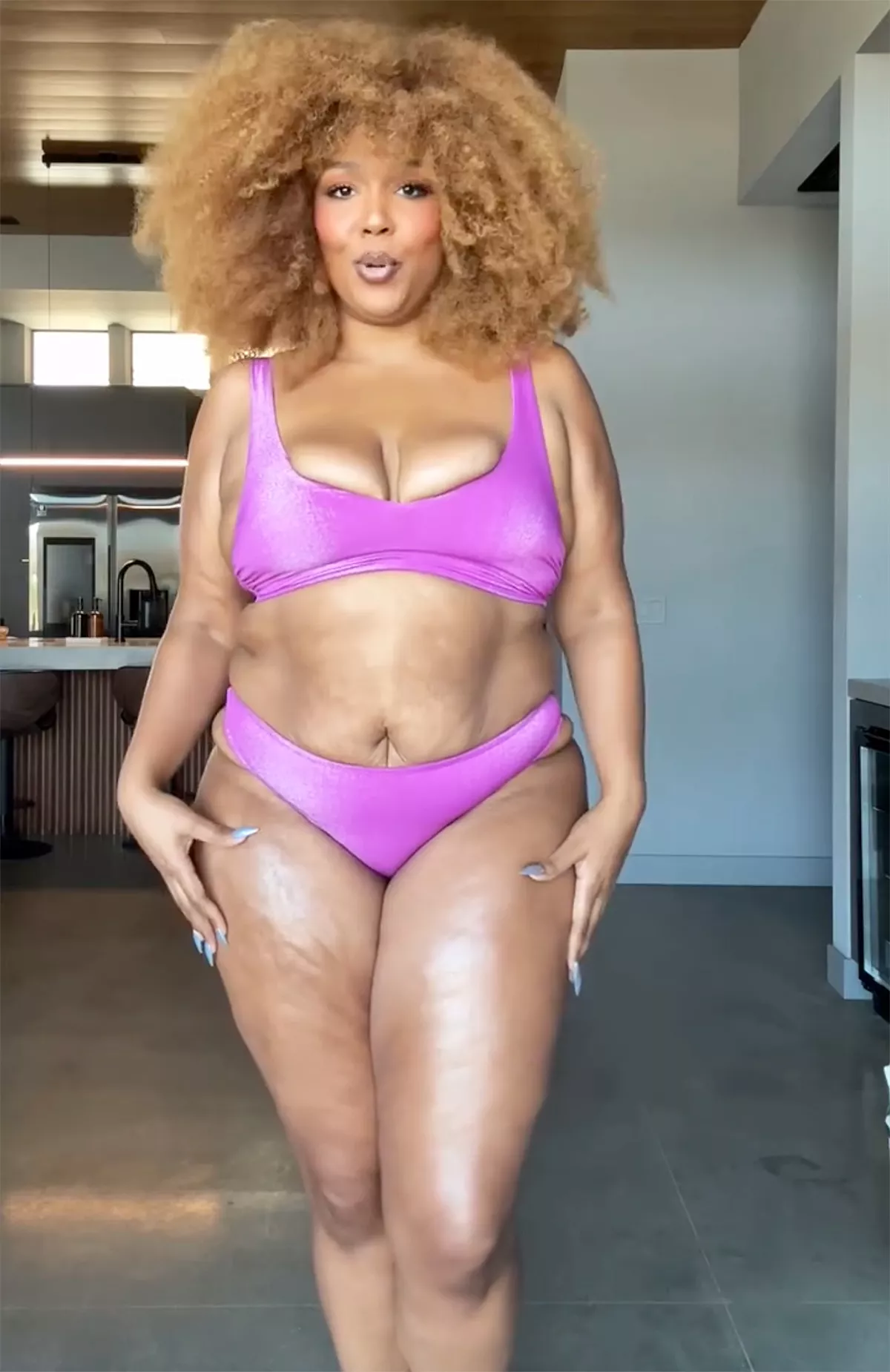 Lizzo modeling a vibrant purple bikini from her Yitty swimwear collection