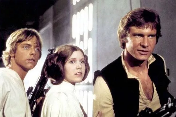 A candid photo of Harrison Ford during the filming of Star Wars, smiling on set