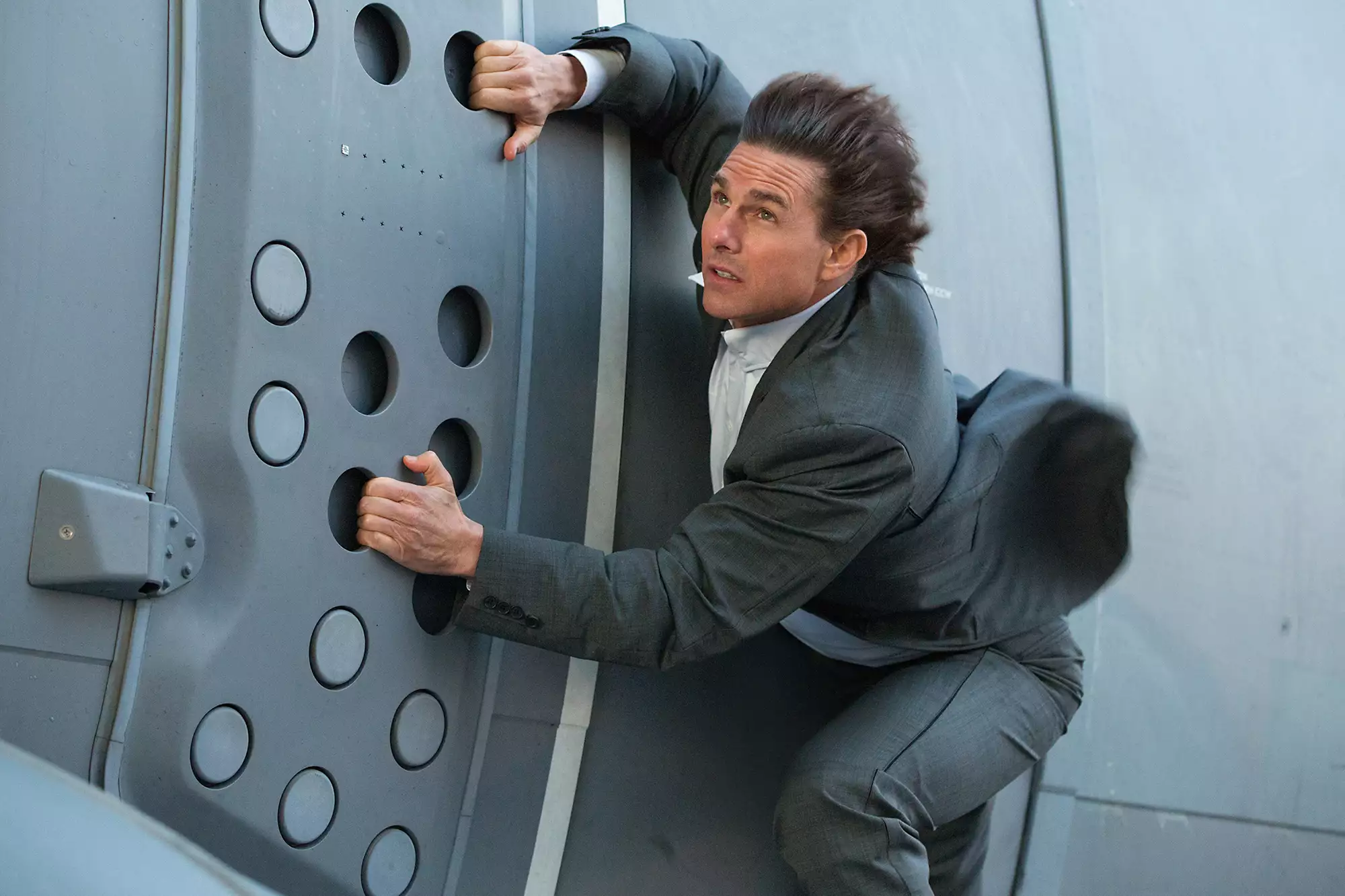Tom Cruise in Mission Impossible performing a dangerous stunt