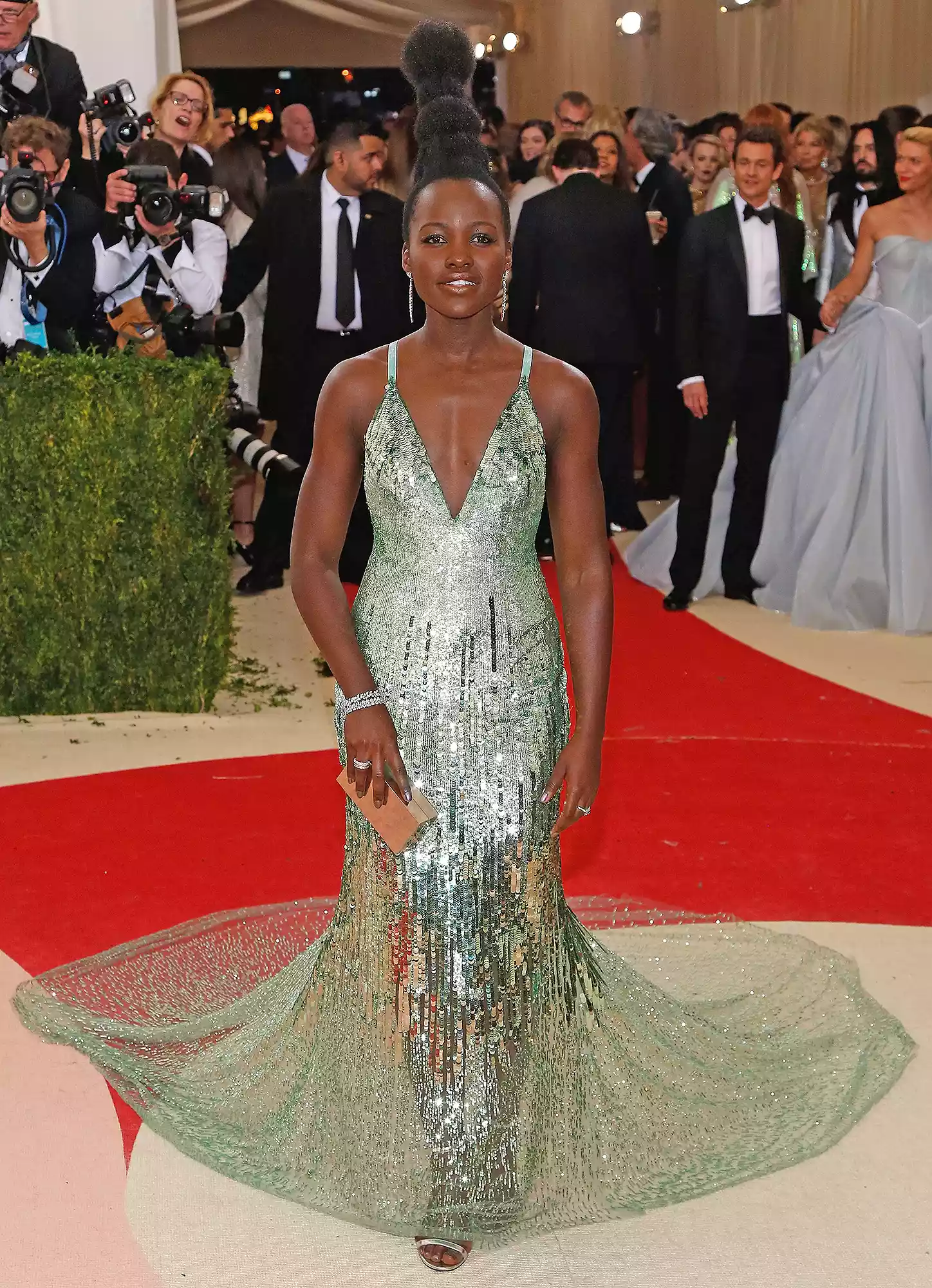 Lupita Nyong'o arriving at the 2025 Met Gala in a pastel green suit and bedazzled eyebrows