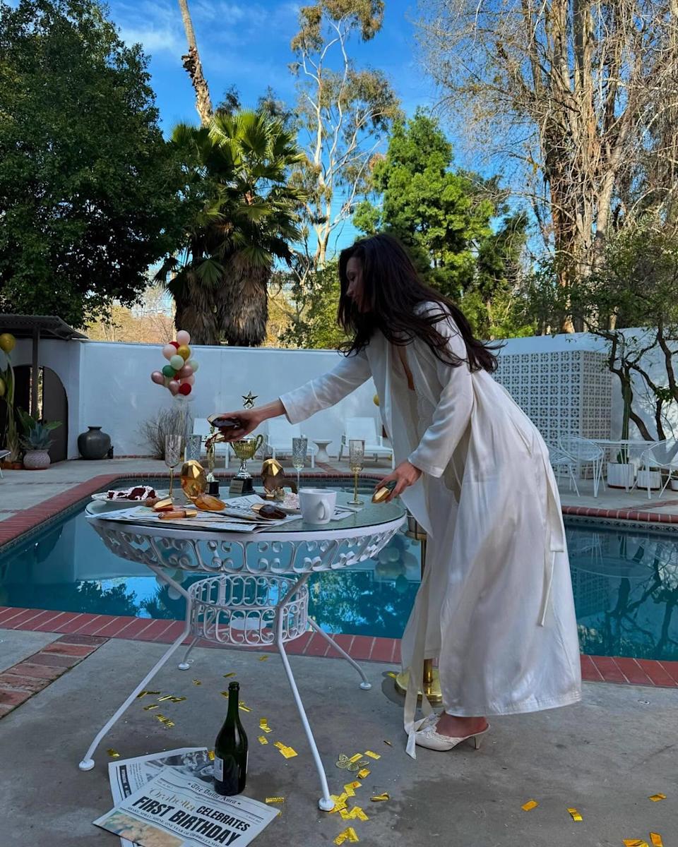 Bella Hadid poolside in retro glamour and curlers, celebrating Orebella’s anniversary