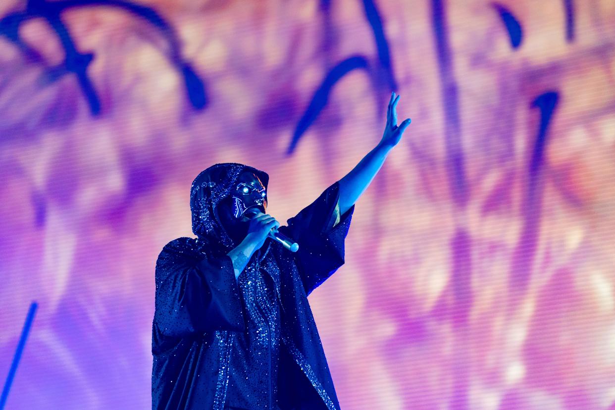 The Weeknd performs on stage during the 2025 tour, with an impressive light show behind him.