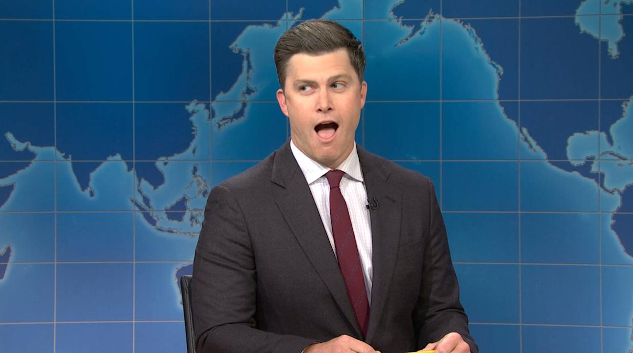 Colin Jost delivering Weekend Update on SNL, showcasing his signature wit and comedic style