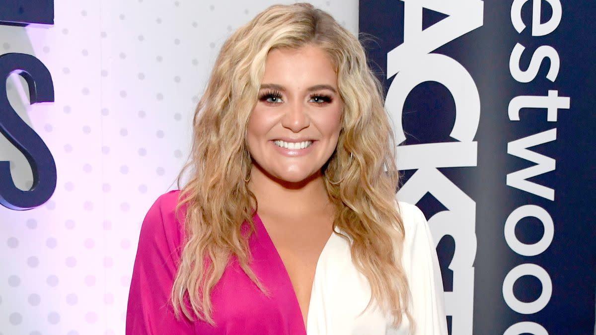 Lauren Alaina smiling at an event, radiating warmth and authenticity.