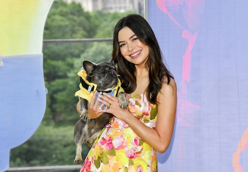 Miranda Cosgrove attends a movie premiere smiling at the camera
