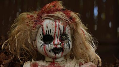 The real Annabelle doll on display, encased in glass
