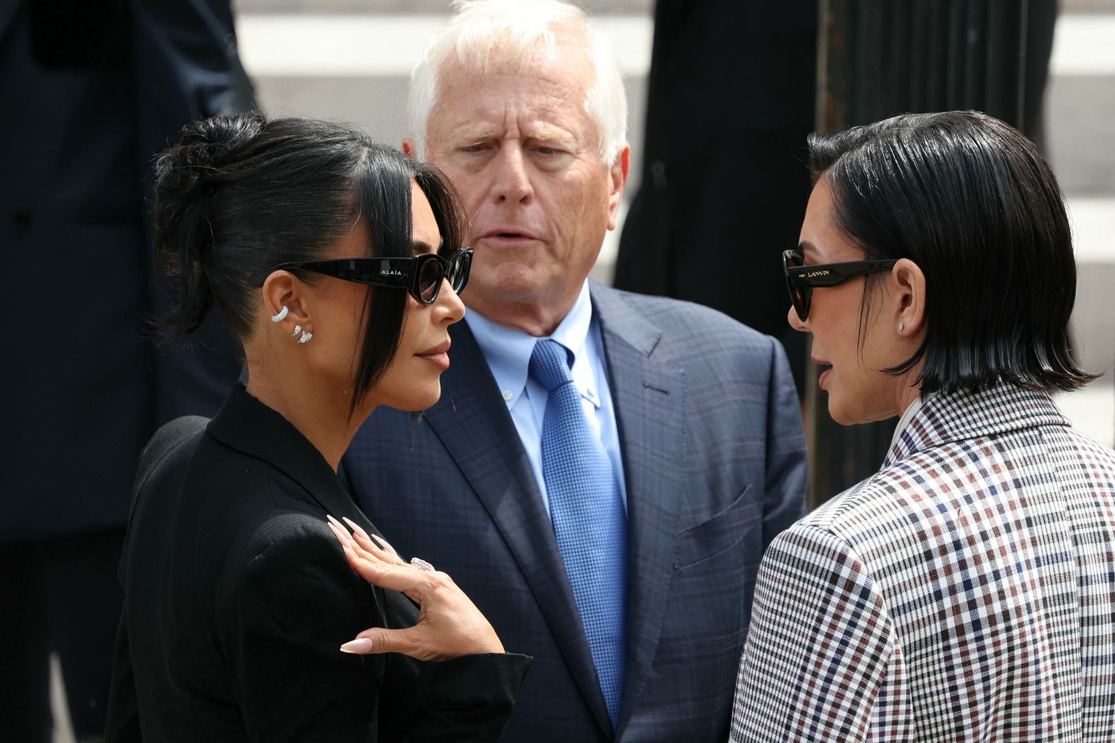 Kris Jenner walking with her signature style, chic black suit and flippy bob hairstyle