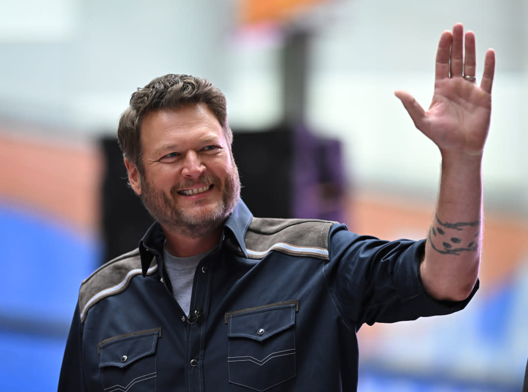 Blake Shelton standing backstage at The Voice finale, smiling at the crowd.