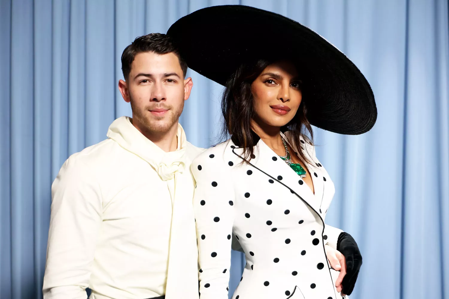 Nick Jonas smiling at an event with his daughter Malti and wife Priyanka Chopra Jonas.